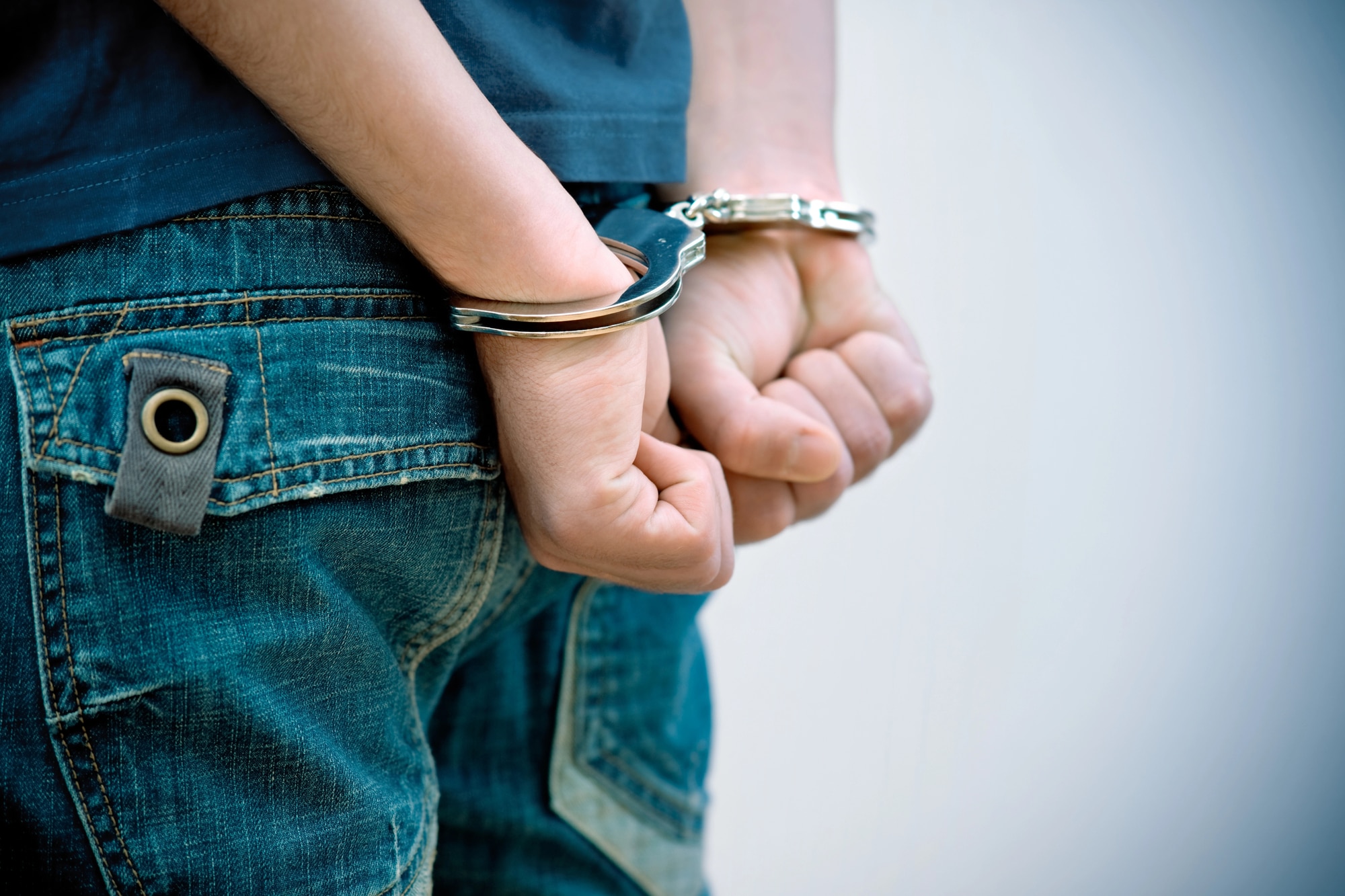 Man wearing jeans in handcuffs